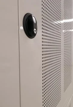 Side view of a locker with mesh grid and a black safety plate holder for a key. 스톡 사진