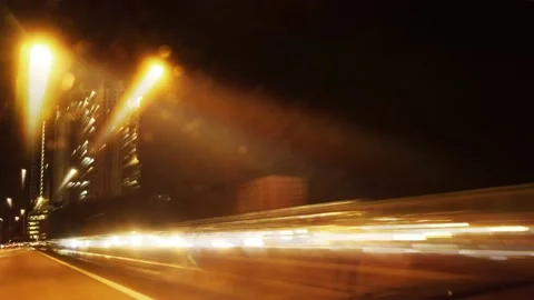 Side view of long exposure light trails of cars driving on highway hyper Stock Footage 136665390