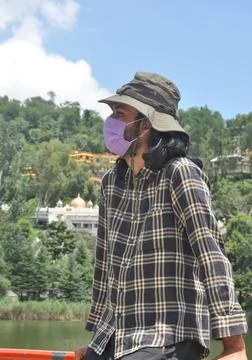 Side view of a long haired young man wearing sun hat and face mask  Stock Photos