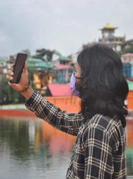 Side view of a long haired young man taking selfie or having video call  Foto stock