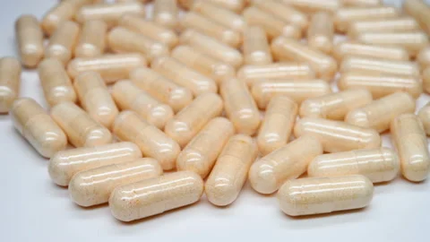 Side view lots of capsules turning Stock Footage 141585273