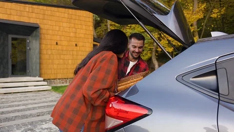 Side view of lovely cheerful young couple of husband and wife which unloading Stock Footage 121665313