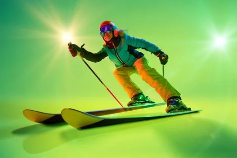 Side view, low angle of athletic woman, skier gliding forward against intense Stock Photos