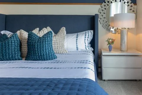 Side view of luxurious large bed with many blue and white pillows Stock Photos