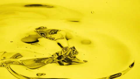 Side view macro of jojoba oil is being poured into yellow oil Stock Footage 230113989