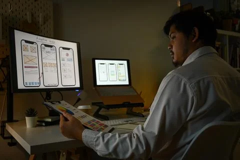 Side view male developer working with template layout for mobile application in Stock Photos