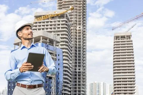 Side view of male engineer standing against background of buildings under con Stockfoto's