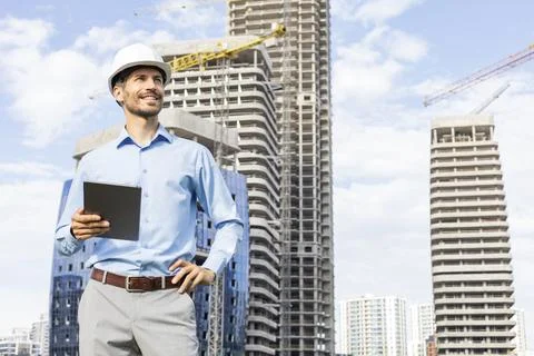Side view of male engineer standing against background of buildings under c.. Stock Photos