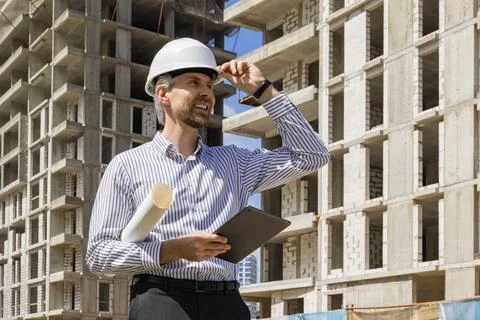 Side view of male engineer standing against background of buildings under c.. Foto stock