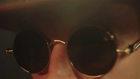 A side view of a male face wearing sunglasses and a hat who is giving a speech 스톡 동영상 325624941