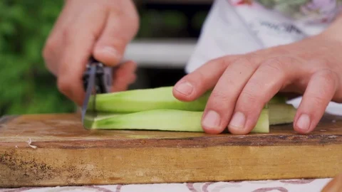 Side view of male hands chopping peeled cucumber on wooden board Stock Footage 111649746