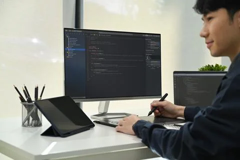 Side view of male programmer working on laptop to check coding in bugging system Stock Photos
