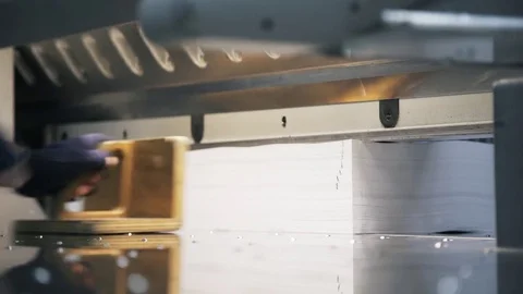 Side view of a male worker cutting a stack of paper in typography Stock Footage 75205905