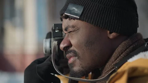 Side view man adjusting camera lens on snowy street under sunny sky Stock Footage 318627012