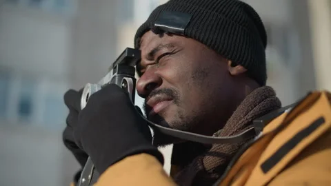 Side view man adjusting camera lens on snowy street under sunny sky Stock Footage 318633478