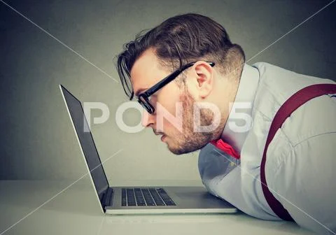 Side view of a man with bad vision having difficulty to read email Stock Photos