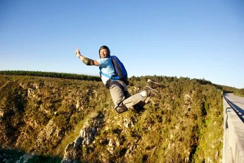 Side view of man base jumping against clear sky Foto stock
