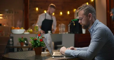Side view - a man is brought an order to a visitor - an espresso and a muffin Video stock 99443711