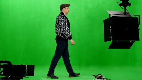 Side view of man in cardigan and flat cap walks on treadmill in chromakey studio Video stock 77751218