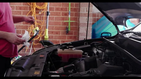Side View of Man Checking Engine Oil With Dipstick in Garage Stock Footage 331508324