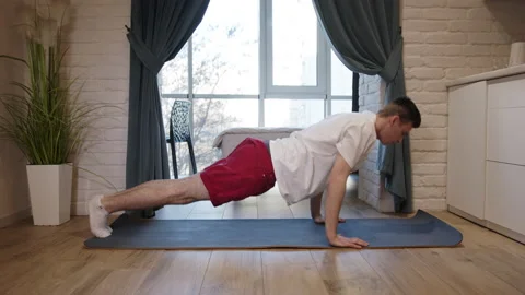 Side view of man doing push ups on fitness mat at home Stock Footage 139042692