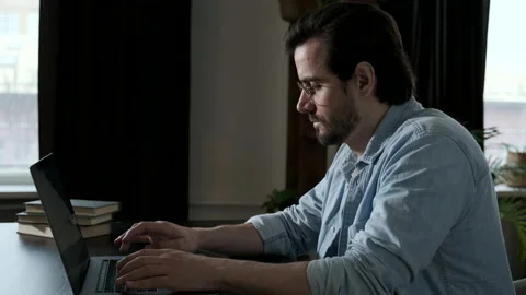 Side View of A man with Glasses, Blue Shirt and White t-Shirt Working Stock Footage 143479040