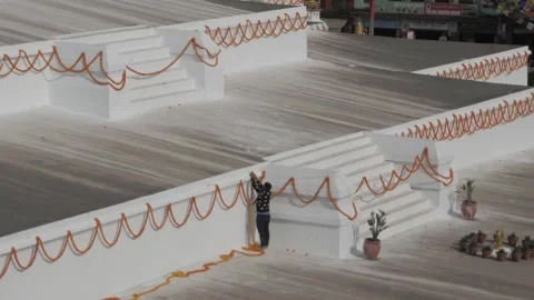 Side view of man hanging chains of marigold rosaries on the wall of Boudha stupa 스톡 동영상 241736083