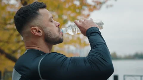 Side View of the Man Jogger Drinking Water after Exercising. Mature Male Drinks Stock Footage 259689919