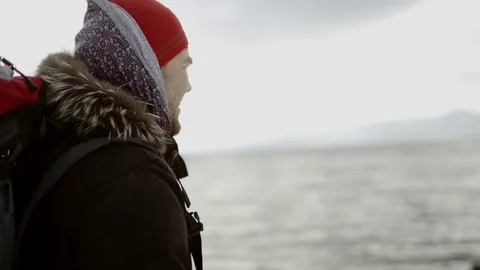 Side view of a man looking at winter lake and smiling Stock Footage 70837088