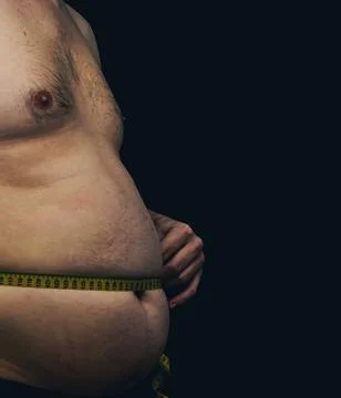 Side view of a man measuring his belly fat with a measuring tape. Stock Photos