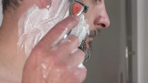 Side view, a man of middle ages shaving his face with a razor, close-up, 4K Stock Footage 135882794