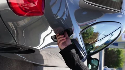 Side view of man opening gas cap cover lid of car to pump petrol.vertical video Vidéo 253826154