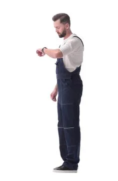 Side view. a man in overalls looking at his wristwatch Stock Photos