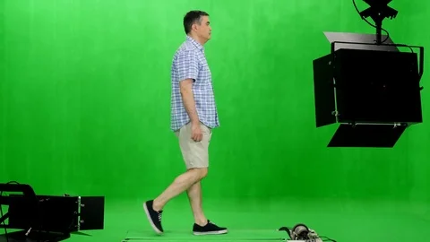 Side view of a man in plaid shirt walks on treadmill in chromakey studio Video stock 77748402