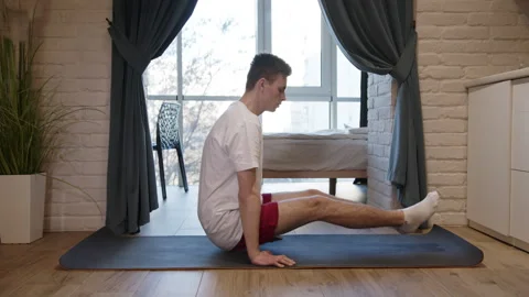 Side view of man practicing handstand in angusthasana and doing lolasana pose Stock Footage 139042566
