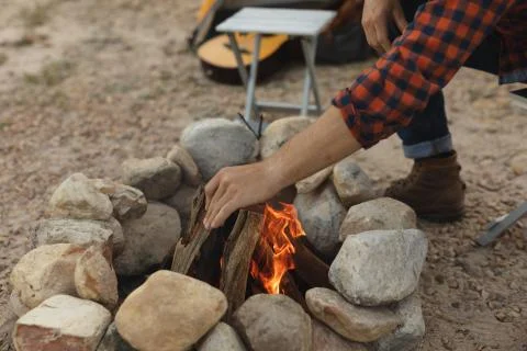 Side view of man preparing the fire of the camp Stock Photos