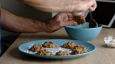 Side view of a man preparing oatmeal, banana and chocolate cookies Stock Footage 128828848