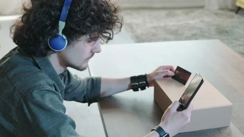 Side view of a man shopping online with credit card using smart phone at home. Stock Footage 155807137