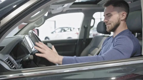 Side view of man sitting in auto and enjoying car interior Stock Footage 100144455