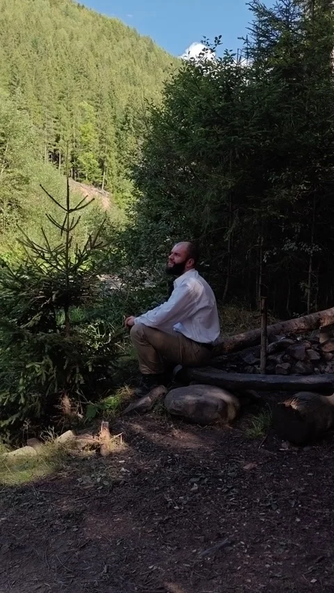 Side View of Man Sitting on Wooden Bench Overlooking Mountain Slope Stock Footage 344981123