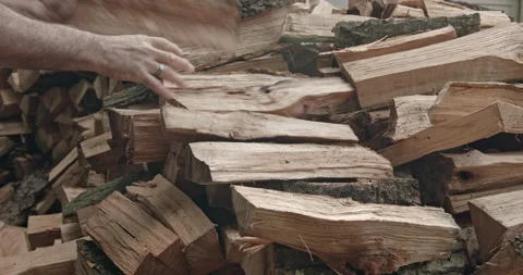 Side view man stacking woodpile, red oak pieces, lifting from ground audio Stock Footage 139989932
