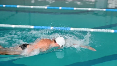 Side view of man swimming freestyle crawl in indoor pool Stock Footage 346768157