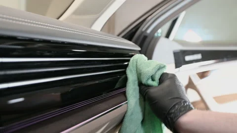 Side view of man taking care of car interior in garage. Cleaning dashboard with Stock Footage 153249242