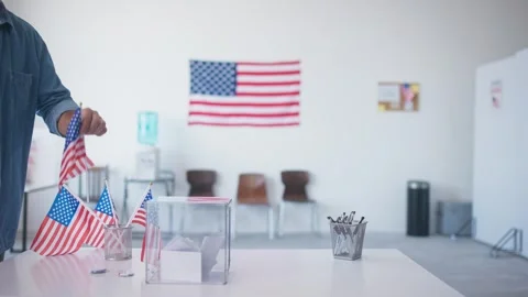 Side view of man throwing ballot into voting basket at polling station. Voter Stock Footage 282438581