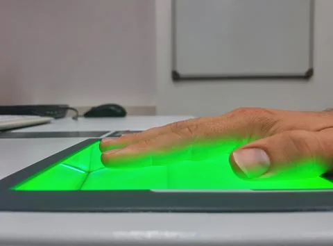 Side view from a man using a fingerprint scanner for identification. Biometrics Stock Photos