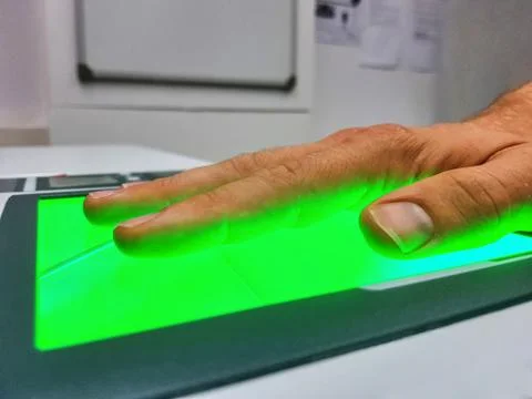 Side view from a man using a fingerprint scanner for identification. Biometrics Stock Photos