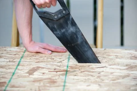 Side view of a man using a hand saw with motion blur Stock Photos