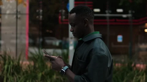 Side view of the Man Using Phone on City Sidewalk Stock Footage 329052870