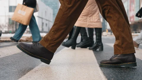 Side view man walking across city crosswalk on sunny winter day. Male feet steps Stock Footage 326826180