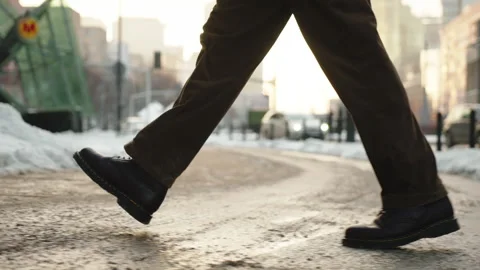 Side view man walking across city street sidewalk on sunny winter day Stock Footage 326826750